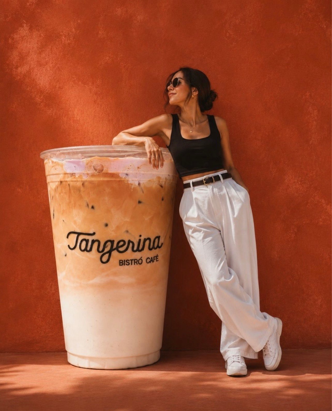 Campaña de Tangerina Bistró Café, con una bebida de café frente a una pared naranja.